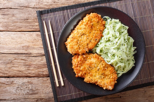 chicken cutlets in breadcrumbs Panko and noodles with green tea Macha on the table. horizontal view from above Captions are provided by our contributors.