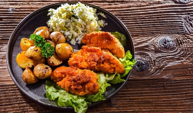 Breaded chicken cutlets served with potatoes and cabbage